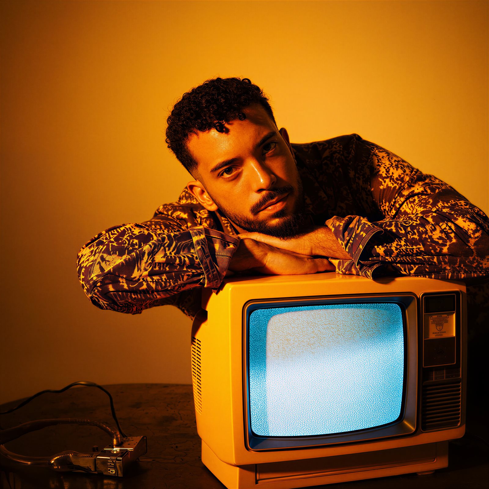 VIRGOH apoiado sobre uma TV retrô, em luz âmbar